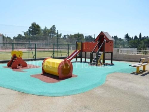un parc avec une aire de jeux avec un toboggan et un toboggan dans l'établissement Le lagon bleu piscine et tennis, à Fréjus