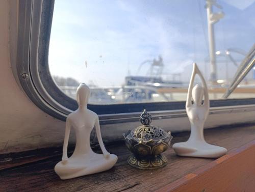 three statues sitting on a window sill next to a vase at Evasion Romantique sur le Rhône in Valence
