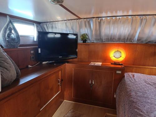 a bedroom with a tv and a bed and a lamp at Evasion Romantique sur le Rhône in Valence