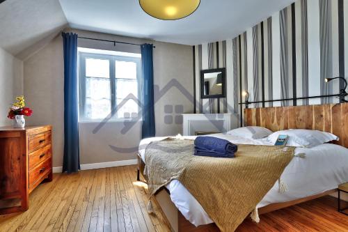 a bedroom with a bed with a laptop on it at LocaLise - M6A - Ty Heol - Maison de vacances à quelques pas du port et des plages - jardin avec terrasse entièrement clos - wifi inclus in Tréffiagat