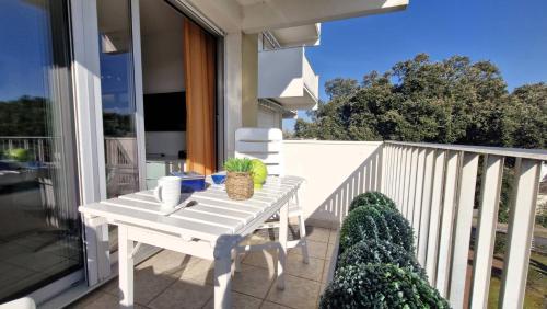 - une table blanche sur le balcon d'une maison dans l'établissement Saint Palais sur Mer - APERCU MER pour ce SUPERBE APPARTEMENT - une pépite, à Saint-Palais-sur-Mer