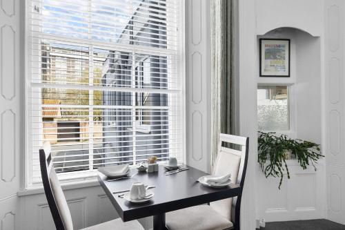 a dining room with a table and chairs and a window at Imperial Plymouth in Plymouth