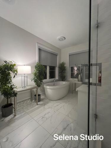 a white bathroom with a tub and a shower at French Style Mansion In Prestigious Angus Glen Markham in Markham