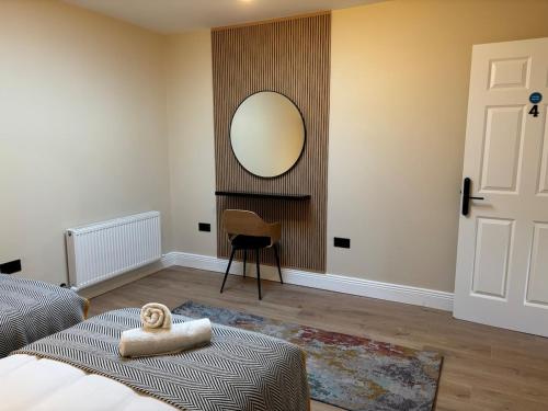 a bedroom with a mirror and a bed and a chair at Riverside Loft Group Accommodation in Kilkenny