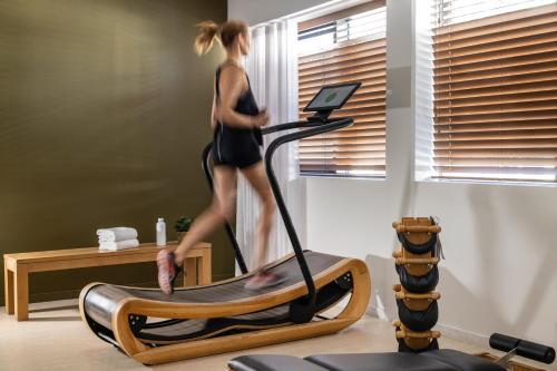 a woman running on a treadmill in a room at Belaroïa Montpellier Centre Saint Roch in Montpellier