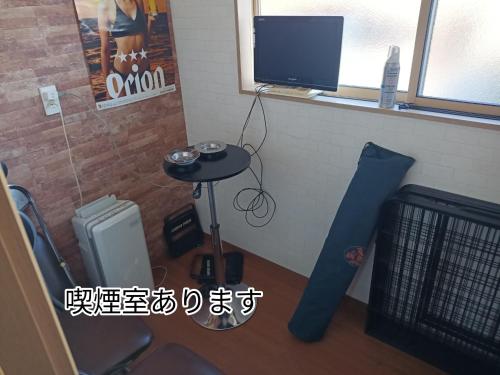 a room with a table and a tv and a table with a table at Guest House Ihatov - Vacation STAY 22102v in Takamatsu
