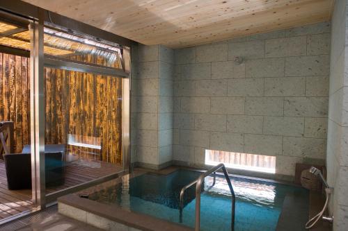 a pool in a house with a wooden ceiling at Onsen Ryokan Yamaki in Nasushiobara