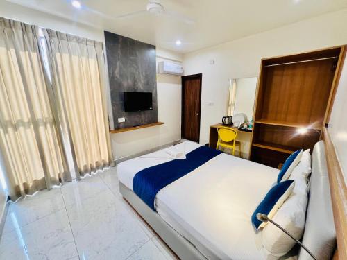 a hotel room with a bed and a television at Sterling Wood Hotel in Bengaluru