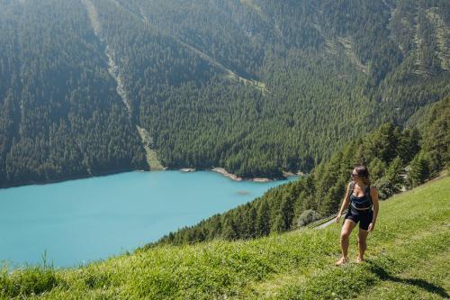 a woman standing on a hill overlooking a lake at Aparthotel Maso Corto in Maso Corto