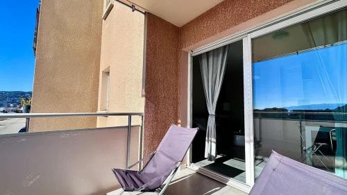 d'un balcon avec une chaise violette et une fenêtre. dans l'établissement Casamea - Vue Mer, Clim & Parking, Proche Plage, à Ajaccio