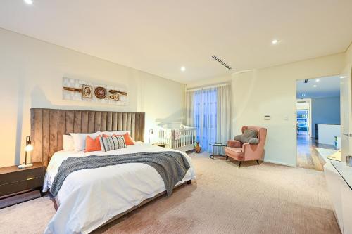 a large bedroom with a bed and a chair at Cozy Darbs in Perth