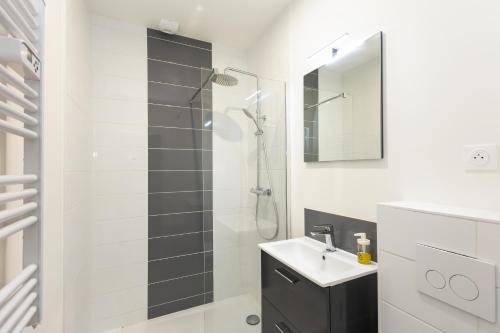 une salle de bain blanche avec une douche et un lavabo dans l'établissement T2 Le Téméraire, à Brest