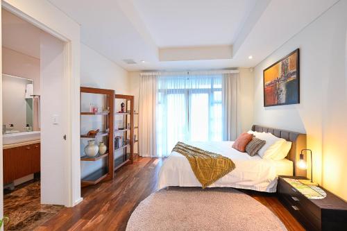 a bedroom with a large bed and a bathroom at Cozy Darbs in Perth