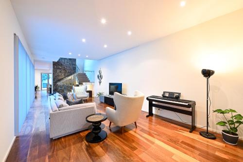 a living room with a couch and a piano at Cozy Darbs in Perth