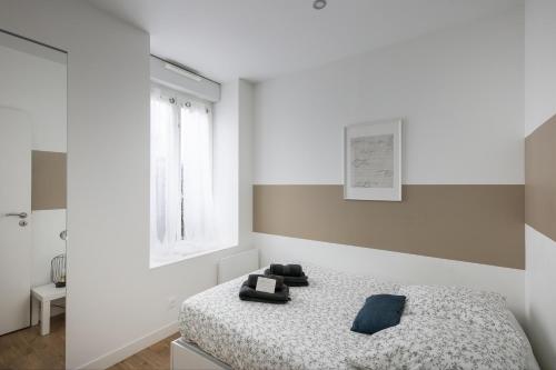 une chambre blanche avec un lit et une fenêtre dans l'établissement T2 Le Téméraire, à Brest