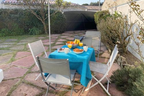 une table avec un chiffon bleu et de la nourriture dans l'établissement Cozy retreat near the beach terraces and parking, à La Flotte