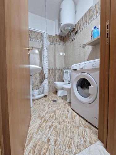 a bathroom with a washing machine and a toilet at Sea Grand Apartament in Vlorë