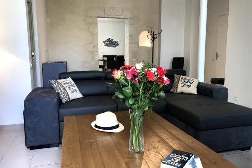 a living room with a vase of flowers on a table at Cozy House with Free Private Parking in Saint-Martin-de-Ré