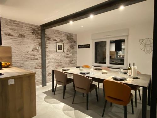 une cuisine et une salle à manger avec une table et des chaises dans l'établissement Beach house Maison de plage les pieds dans l eau, à Plérin