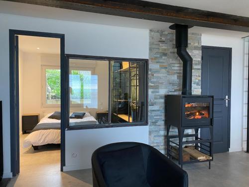 un salon avec une cheminée et une chambre dans l'établissement Beach house Maison de plage les pieds dans l eau, à Plérin