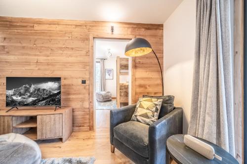 un soggiorno con sedia e TV di Apartment Aubretia, Les Houches - by EMERALD STAY a Les Houches