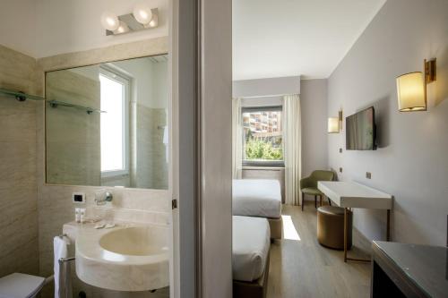 a bathroom with a sink and a bed and a mirror at Hotel Marc'Aurelio in Rome