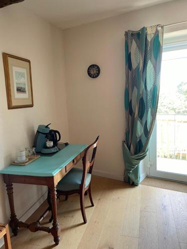 Habitación con mesa, silla y reloj en Entre REDARES et SALENDRINQUE, en Lasalle