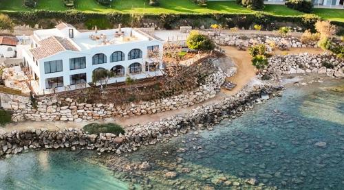 an aerial view of a house next to a body of water at Sirena Bay Beach House and Luxury Suites in Protaras
