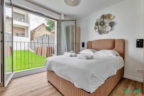 Un dormitorio con una cama grande y una ventana grande. en Résidence Saint-Amand - Proche Paris et Disneyland, en Champigny-sur-Marne