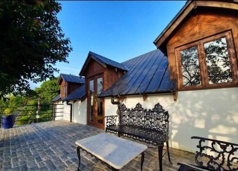 a bench sitting outside of a house with a building at English Cottage House Tagaytay in Calaca