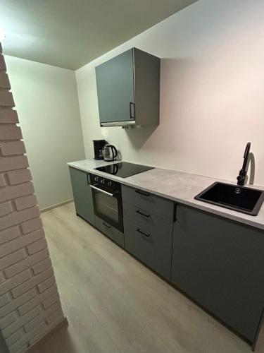 an empty kitchen with a sink and a stove at Small newly renovated apartment in Sandefjord