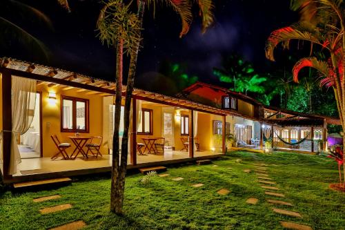 a rental house at night with a hammock in the yard at Pousada Recanto do Arraial in Arraial d'Ajuda