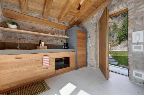 a kitchen with wooden cabinets and a large window at Casa Limonaia al Pos in Tignale