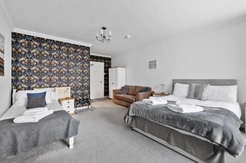 a bedroom with two beds and a couch at Imperial Plymouth in Plymouth