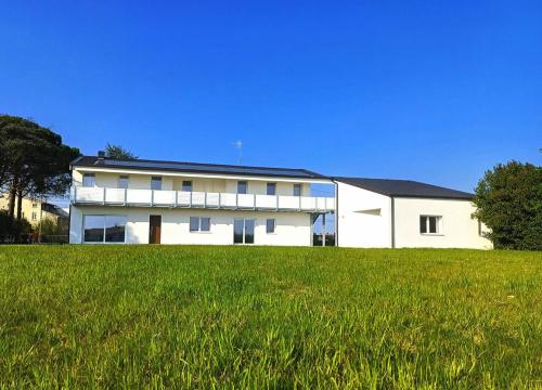 パドヴァにあるSECRET SUNSET - Brand New 2025 HOUSEの前に芝生がある白い建物