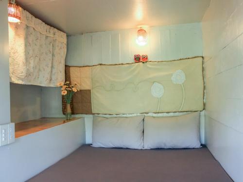 a small room with two pillows and a window at Cú Trên Cây Homestay in Xuan An