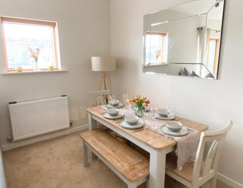 a dining room with a table and a mirror at Stunning Marina Apartment in Portishead
