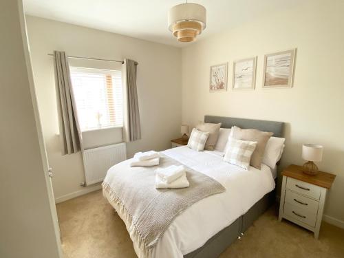 a bedroom with a bed with two towels on it at Stunning Marina Apartment in Portishead