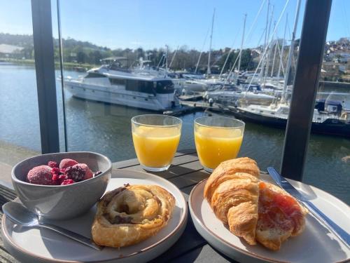 a table with two plates of pastries and a bowl of fruit at Stunning Marina Apartment in Portishead