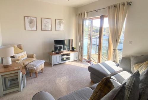 a living room with a couch and a tv at Stunning Marina Apartment in Portishead