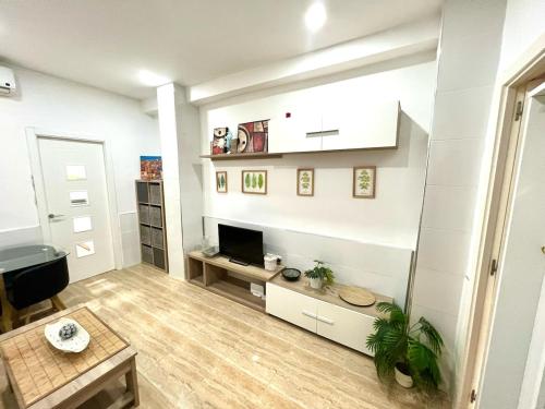 a living room with white walls and a fireplace at Rosaleda Centro Apartamento in Málaga