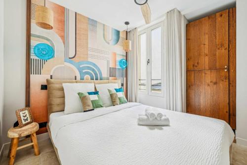 une chambre avec un grand lit blanc et une chaise dans l'établissement Appartement central 2BDR - 6P le Marais, à Paris