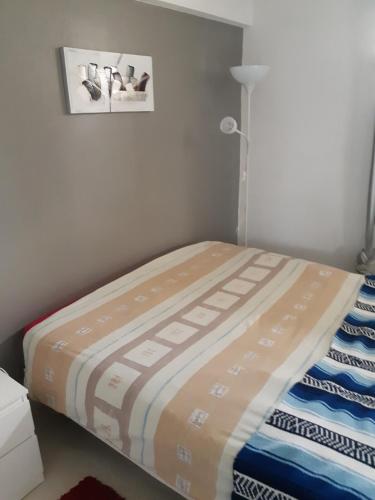 un lit dans une chambre avec un tableau sur le mur dans l'établissement Gite classé touristique belle piscine 8kmd'Avignon, à Entraigues-sur-la-Sorgue