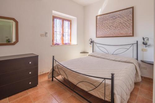 a bedroom with a bed and a dresser and a mirror at Casale Fattoria Benaris With Private Pool - Marsiliana in Marsiliana