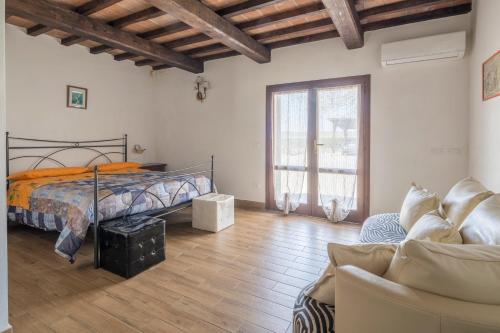 a bedroom with a bed and a couch at Casale Fattoria Benaris With Private Pool - Marsiliana in Marsiliana