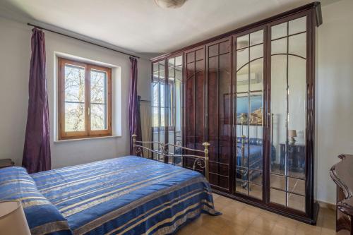 a bedroom with a bed and a large window at Casale Fattoria Benaris With Private Pool - Marsiliana in Marsiliana