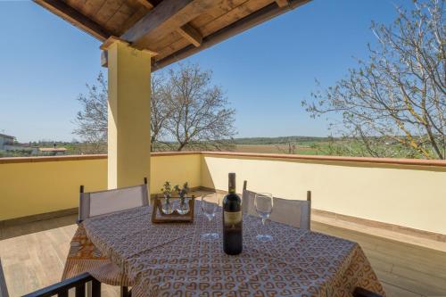 a table with a bottle of wine on a balcony at Casale Fattoria Benaris With Private Pool - Marsiliana in Marsiliana
