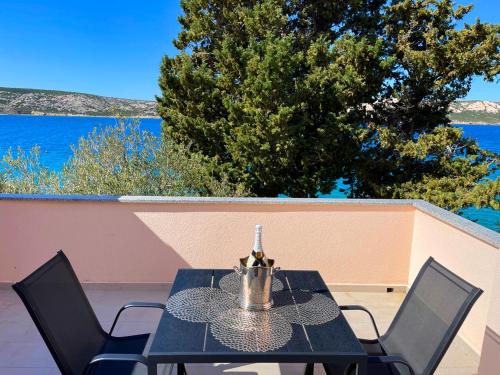 a black table and chairs with a view of the ocean at Villa Olivija-direkt am Strand! in Stara Novalja