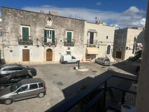 a parking lot with cars parked in front of a building at Suite LA PETRA in Ceglie Messapica
