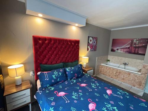 a bedroom with a bed with a red headboard and a bath tub at Garsoniera Riviera in Bacău
